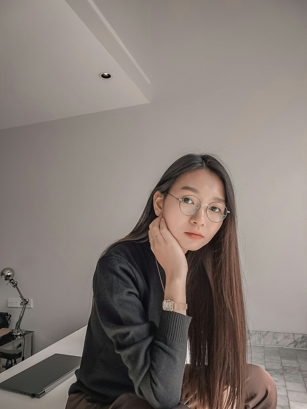 a woman with glasses sitting on a counter