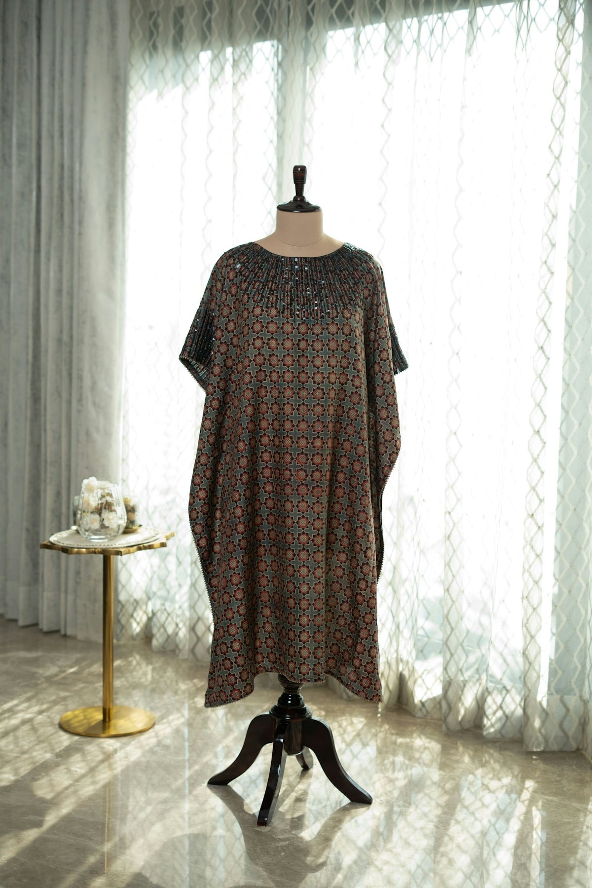 A dress on a mannequin in front of a window