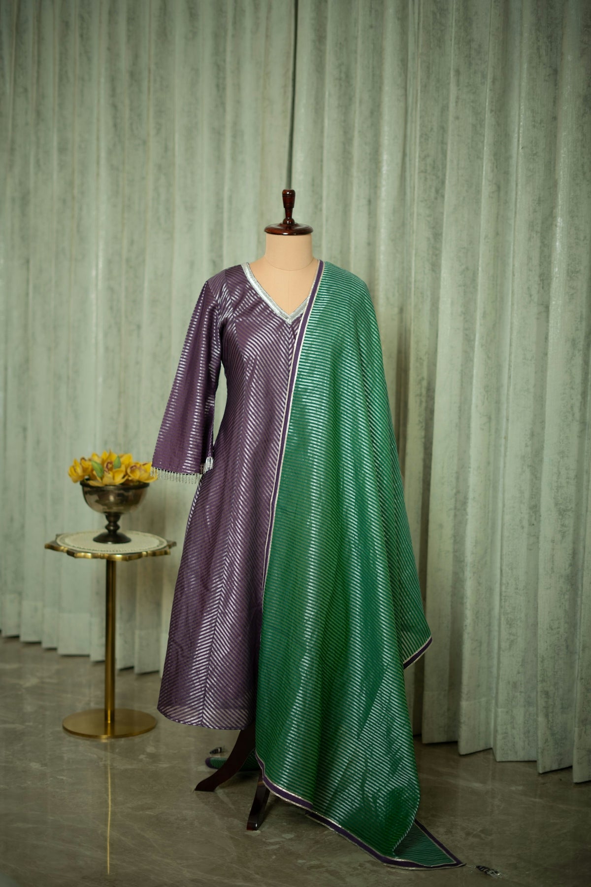 A dress on a mannequin in front of a curtain